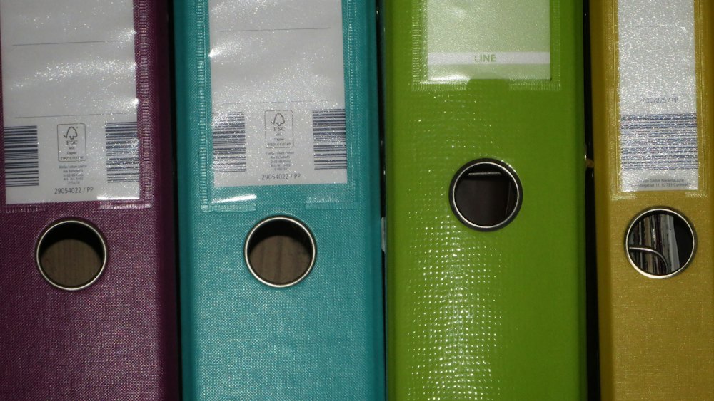 Aktenordner mit Etiketten und Barcodes in einem Regal